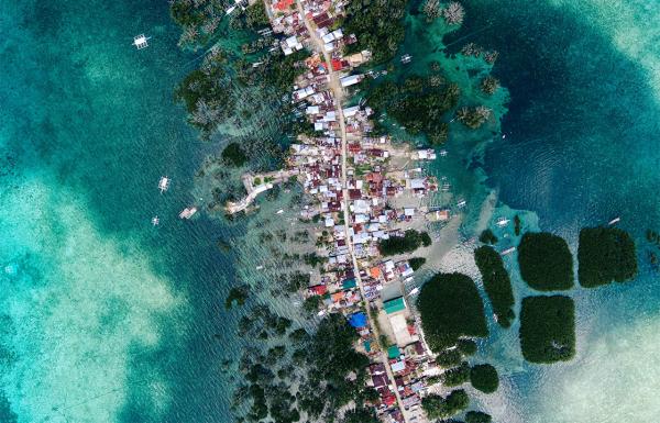 Filipinos wade through floodwaters due…